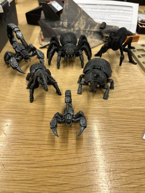 A pack of scorpion and spider miniatures on the table