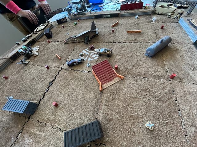 A Gaslands arena laid out with containers, ramps and a wrecked helicopter